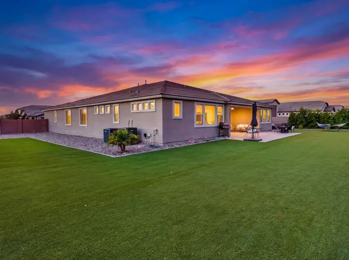 The same backyard photographed at twilight with lights on
