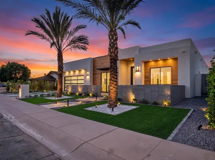 Modern home exterior at twilight with palm trees